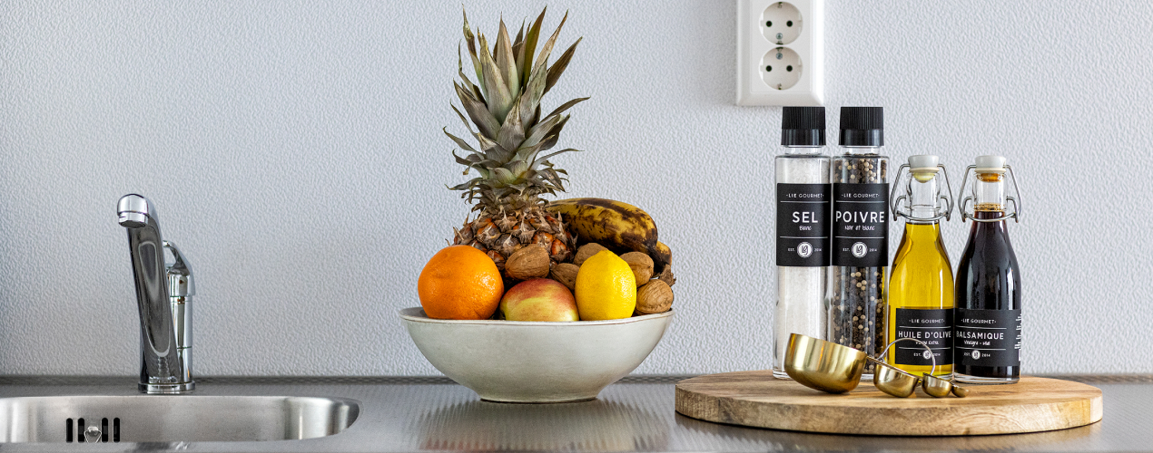 Küche mit einer Spüle, einer Schale Obst und Gewürzen