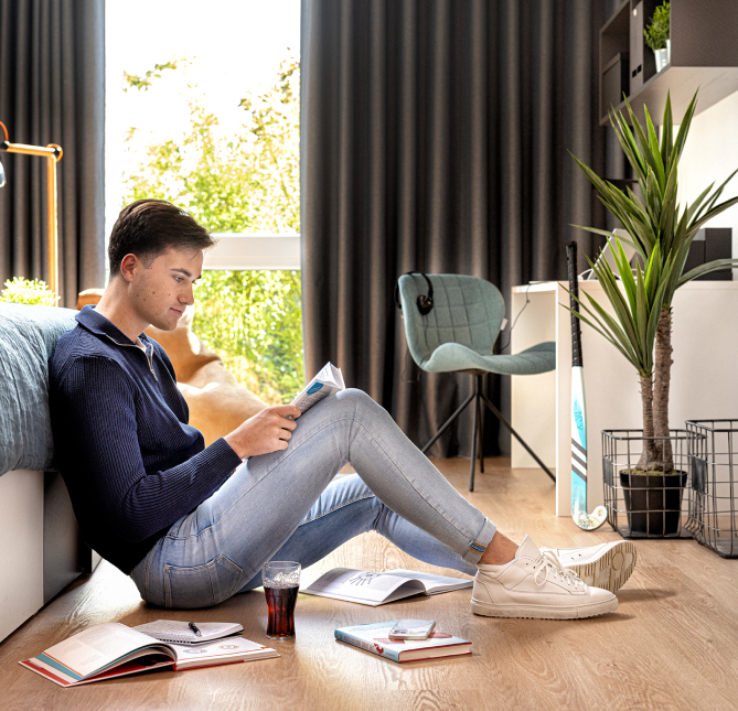 Student am Lesen in seiner Wohnung