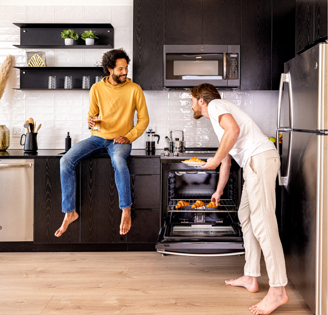 Zwei Männer befinden sich in der Küche eines Apartments