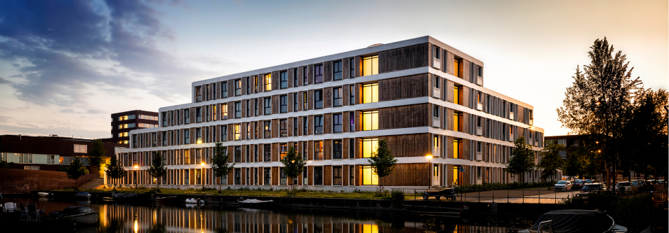 Wohnkomplex mit Apartments am Wasser bei Nacht