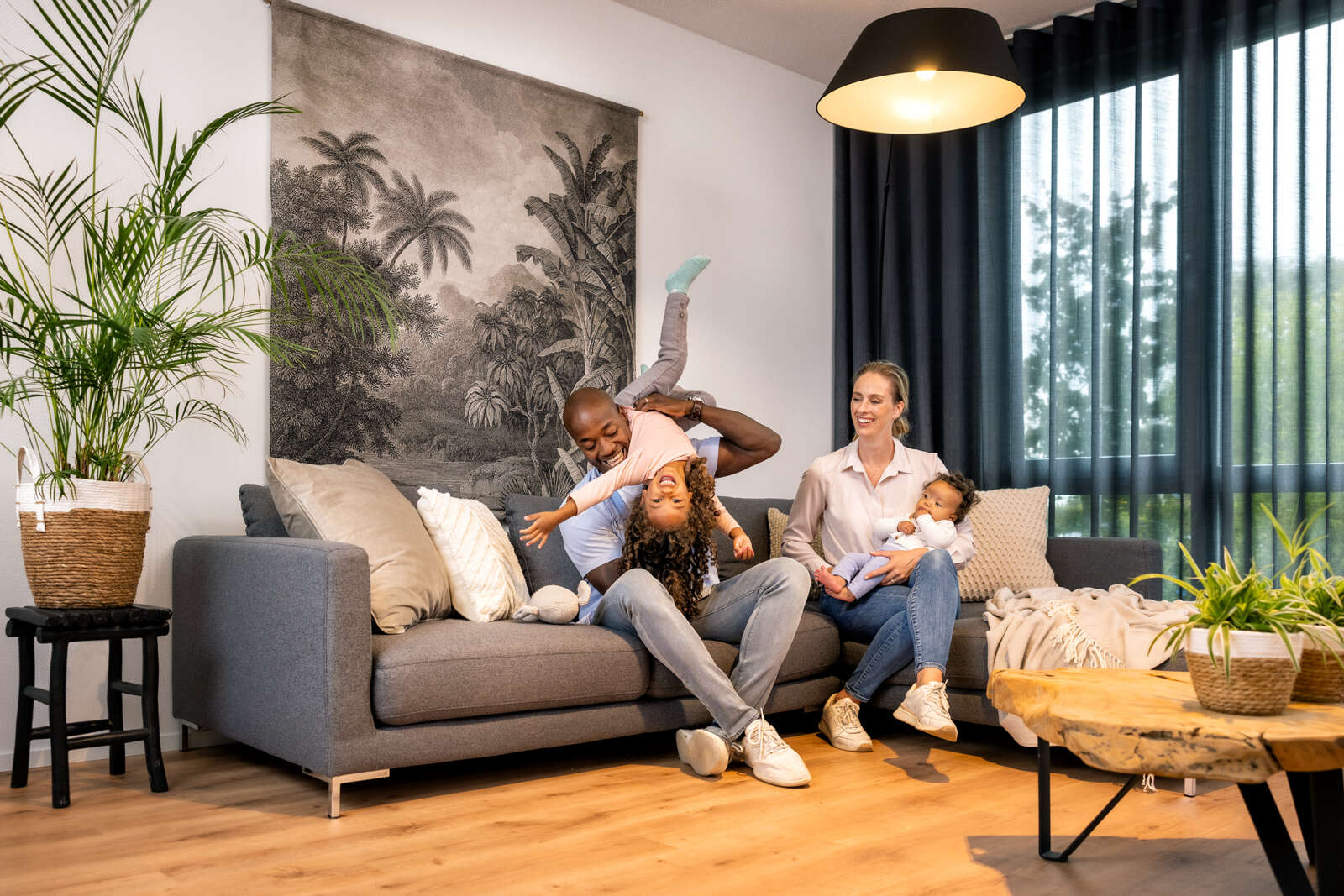 Familie sitzt im Wohnzimmer ihres Reihenhauses.