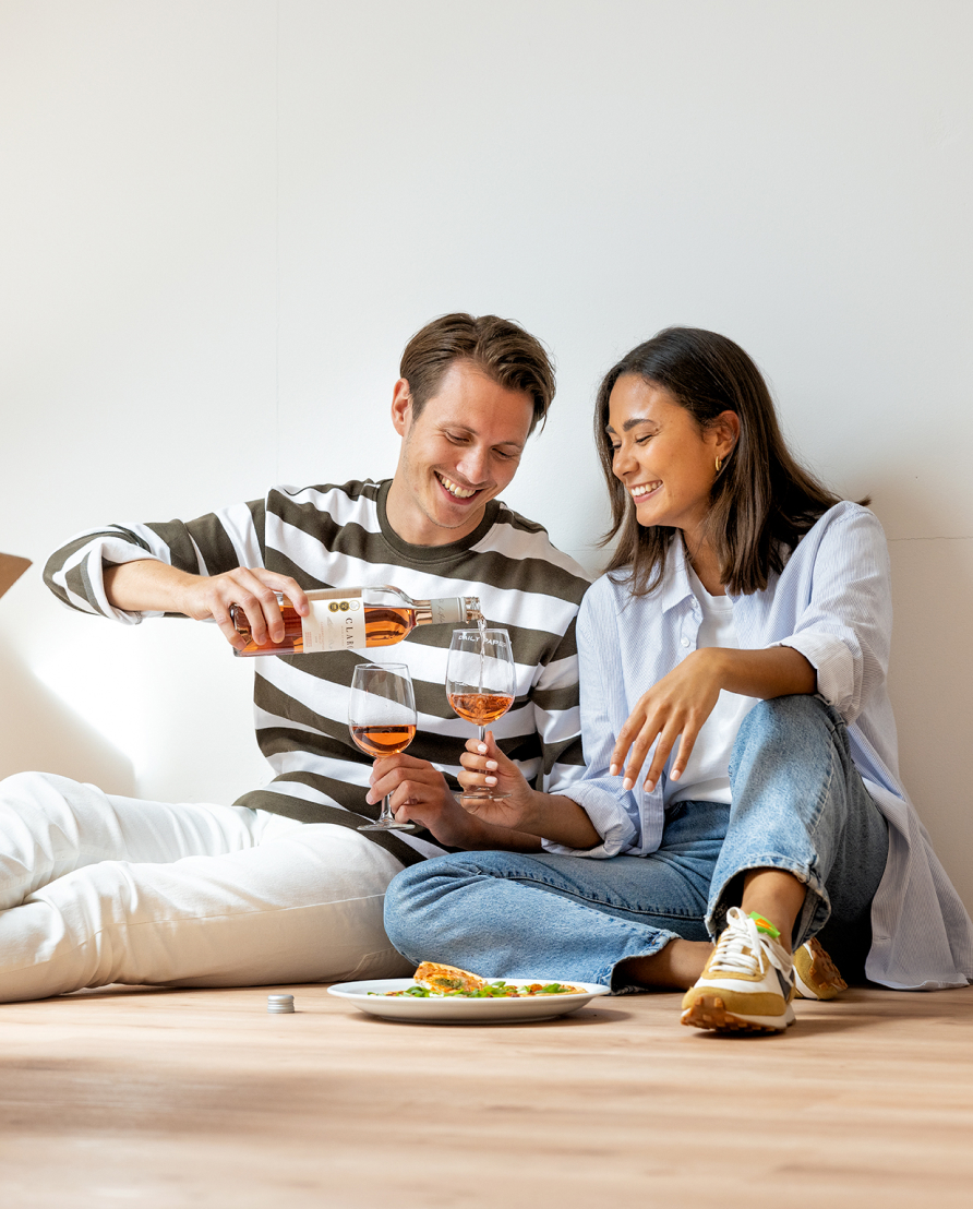 Ein Paar isst auf dem Boden ihres Apartments zu Abend